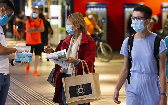 Wer hat noch keine? Ein Freiwilliger verteilt im Bahnhof Bern Schutzmasken.