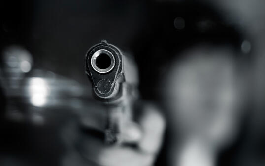 Black and white, woman pointing old gun to front