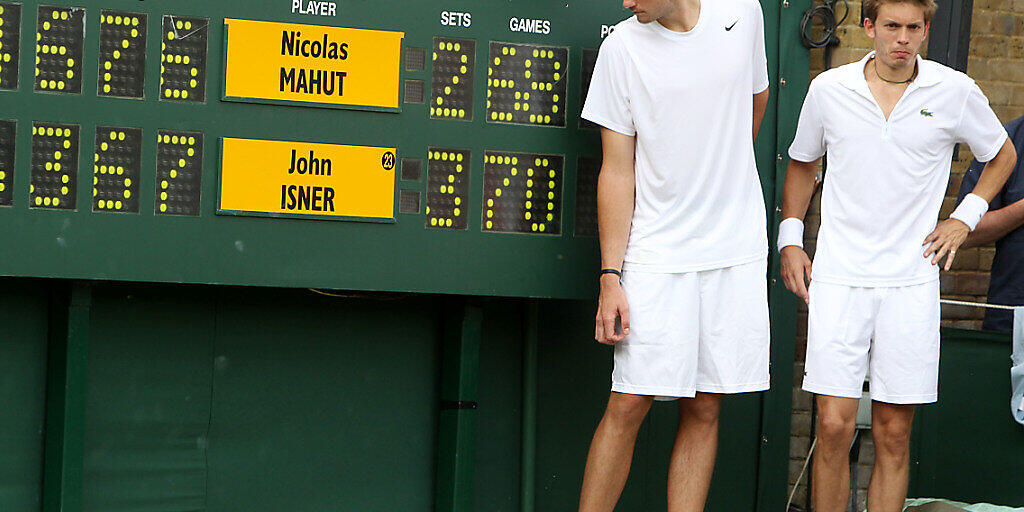 John Isner (links) und Nicolas Mahut posieren im Jahr 2010 vor der Anzeigetafel auf dem Court Nummer 18 in Wimbledon, nachdem sie sich zuvor während 11 Stunden und 5 Minuten duelliert haben. Es dürfte für immer das längste Spiel im Profitennis bleiben