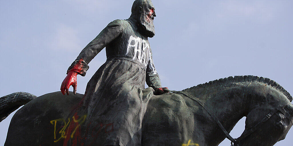 Eine Statue von König Leopold II. von Belgien, die in der Nähe des Königspalastes steht, wurde mit Farben beschmiert und mit dem Schriftzug «Pardon» verziert. Foto: Virginia Mayo/AP/dpa