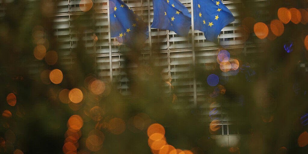 Drei Fahnen in den Farben der EU-Flagge flattern im EU-Hauptquartier im Wind. Foto: Francisco Seco/AP/dpa