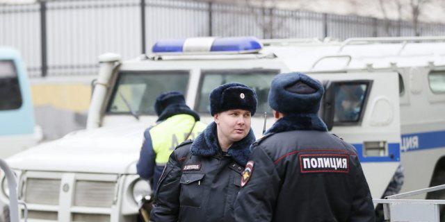 Russische Polizisten nach der Festnahme von Verdächtigen