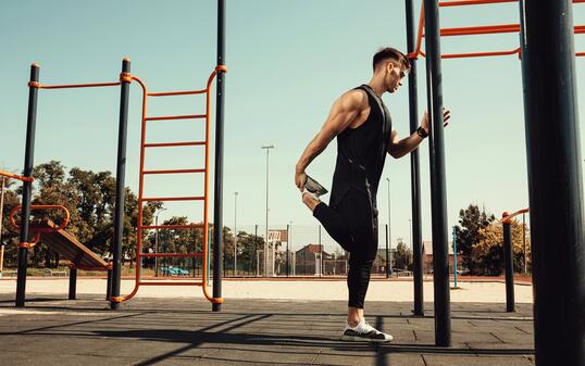 athletic guy warms up before classes on the horizontal bar