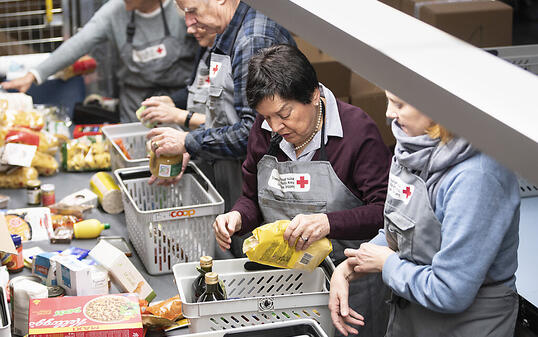 Freiwillige Helfer des Schweizerischen Roten Kreuzes kontrollieren und sortieren den Inhalt von gespendeten Paketen der Spendenaktion "2x Weihnachten". (Archivbild)
