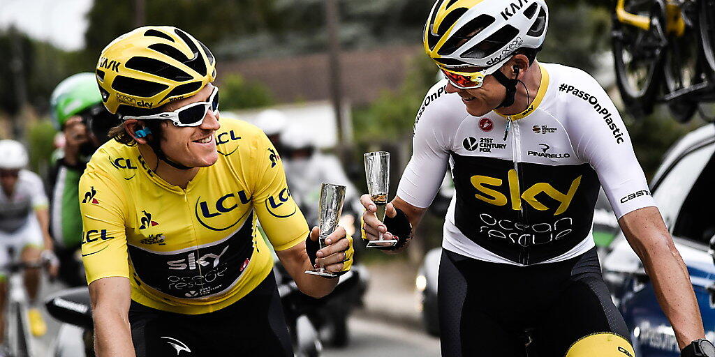Geraint Thomas (links) und Chris Froome genehmigen sich in der letzten Etappe der Tour de France 2018 ein Glas Sekt. Auch 2019 werden die beiden Briten gemeinsam an der Frankreich-Rundfahrt starten