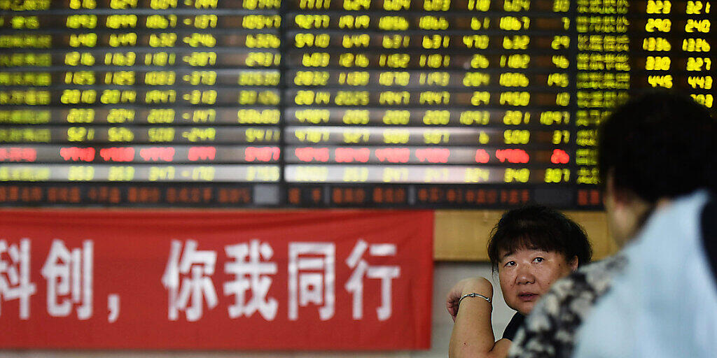 Investorinnnen unterhalten sich vor einem Werbebanner, der bei einem B&ouml;rsenmarkler in Hangzhou in der ostchinesischen Provinz Zhejiang den neu lancierten Star Market anpreist.