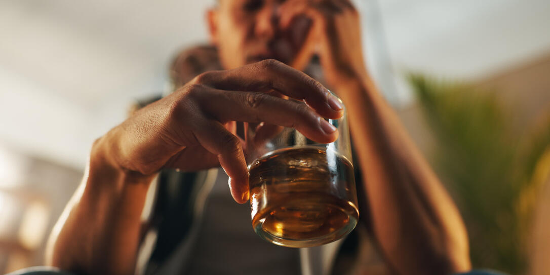 Alcoholic, stress and glass of whiskey with person in living room for substance abuse, risk and depression. Mental health, wine and liquor with drink at home for temptation, withdrawal and control