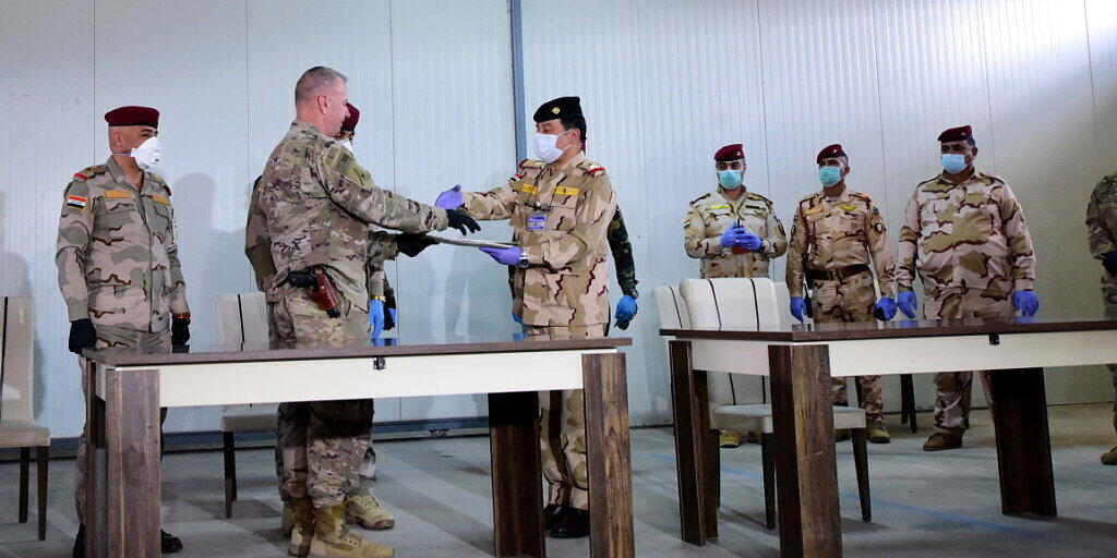 US-Brigadegeneral Vincent Barker (2. links) gibt einem irakischen General bei der Übergabe der Basis K1 an den Irak die Hand. Die von den USA geführte Militärkoalition zog sich am Sonntag von der dritten Basis im Irak zurück. US-Brigadegeneral Vincent Barker (2. links) gibt einem irakischen General bei der Übergabe der Basis K1 an den Irak die Hand. Die von den USA geführte Militärkoalition zog sich am Sonntag von der dritten Basis im Irak zurück.