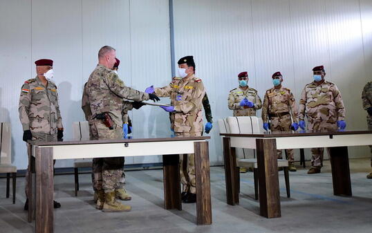 US-Brigadegeneral Vincent Barker (2. links) gibt einem irakischen General bei der Übergabe der Basis K1 an den Irak die Hand. Die von den USA geführte Militärkoalition zog sich am Sonntag von der dritten Basis im Irak zurück.