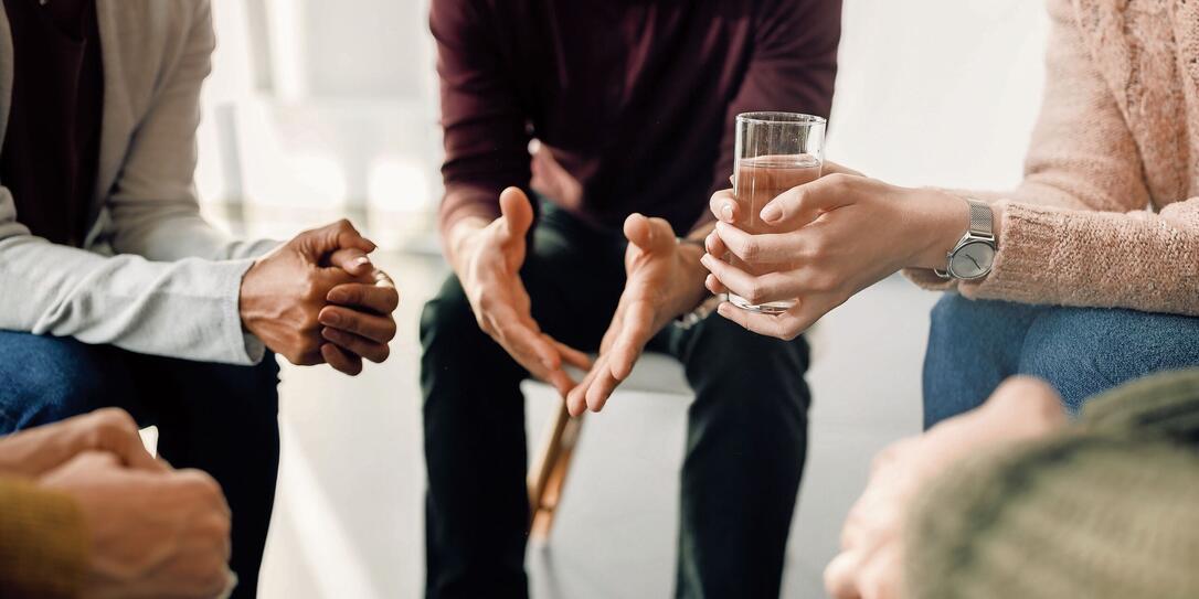 Close-up of people attending group therapy at community center.