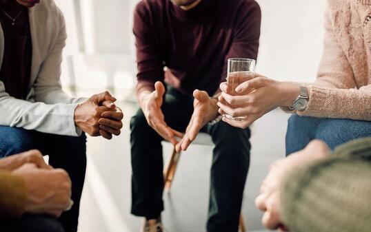 Close-up of people attending group therapy at community center.