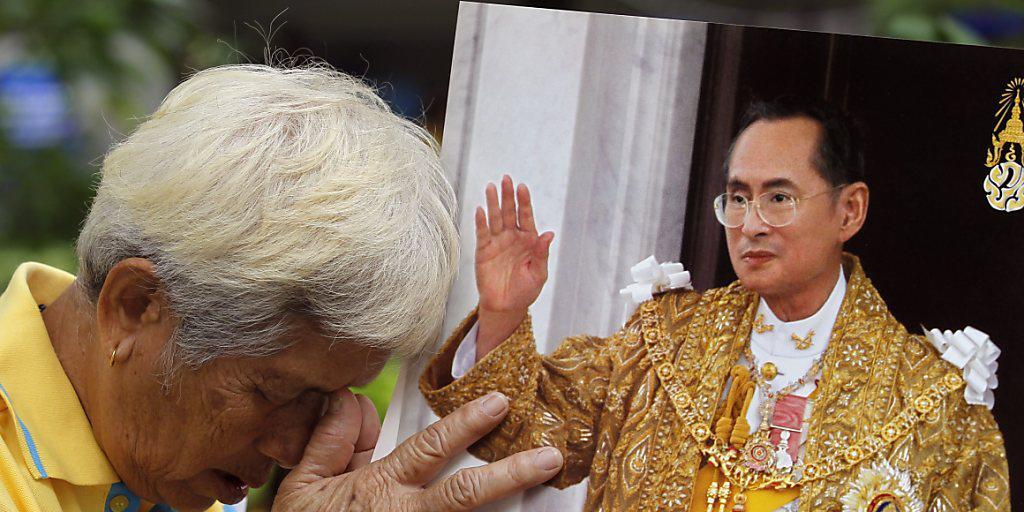Ein Thailänder betet vor einem Bild von König Bhumibol. Der als gottähnlich verehrte Monarch feiert seinen 88. Geburtstag.