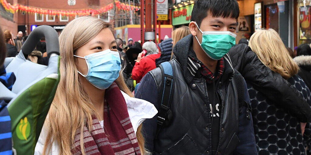 Fussgänger mit Masken in der Londoner Chinatown. In der Schweiz gibt es vorderhand keine bestätigten Infektionen mit dem neuartigen Coronavirus. (Themenbild)