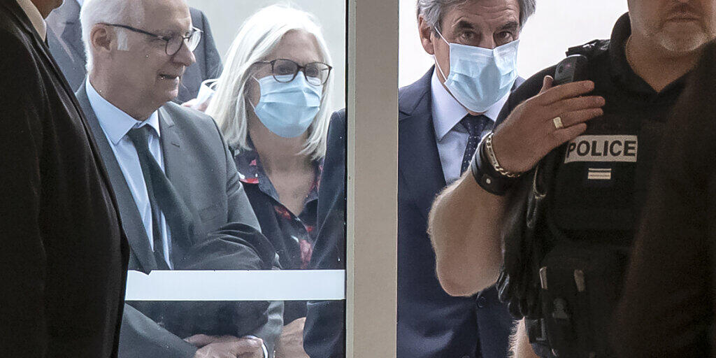 Francois Fillon (Mitte, r), ehemaliger Premierminister von Frankreich, und seine Frau Penelope (Mitte, l) beim Eintreffen im Gerichtsgebäude. Foto: Michel Euler/AP/dpa