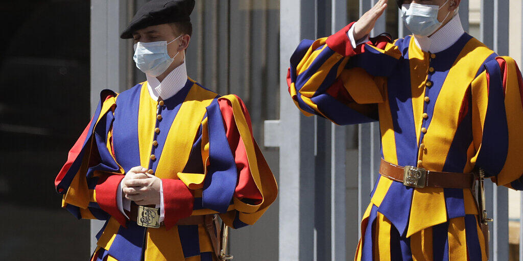 ARCHIV - Zwei uniformierte Gardisten der Päpstlichen Schweizergarde stehen mit Mund-Nasen-Schutz am Eingang zum Vatikan. Foto: Alessandra Tarantino/AP/dpa