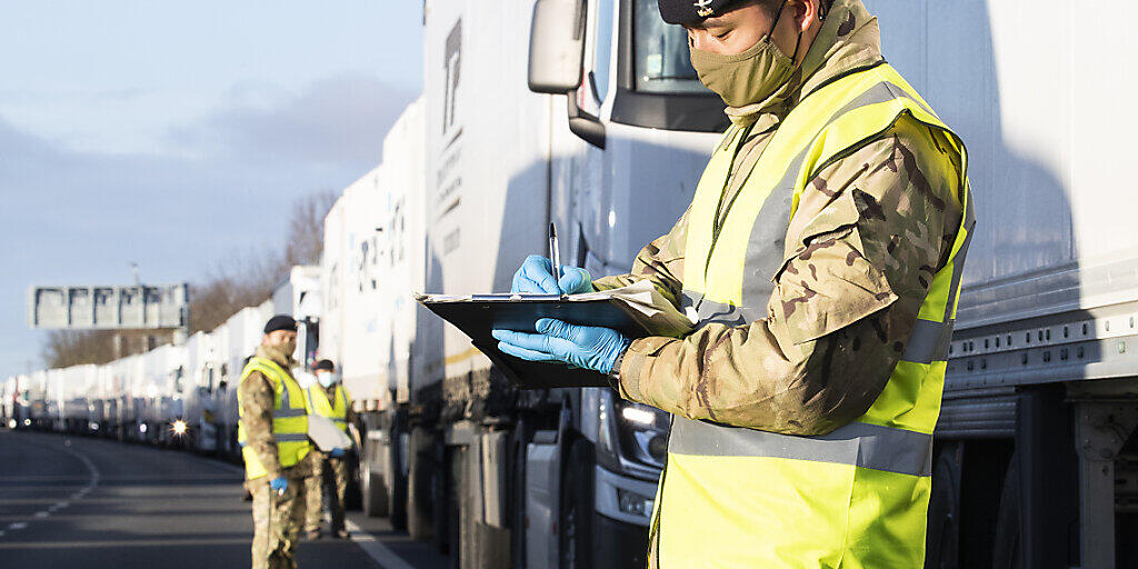 HANDOUT - Das vom Verteidigungsministerium (MoD) herausgegebenes Foto zeigt Soldaten der britischen Armee, die auf der M20 in Kent bei LKW-Fahrer Corona-Tests vorführen. Foto: Cpl Nicholas Egan Raf/MoD/PA Media/dpa - ACHTUNG: Nur zur redaktionellen Verwendung und nur mit vollständiger Nennung des vorstehenden Credits HANDOUT - Das vom Verteidigungsministerium (MoD) herausgegebenes Foto zeigt Soldaten der britischen Armee, die auf der M20 in Kent bei LKW-Fahrer Corona-Tests vorführen. Foto: Cpl Nicholas Egan Raf/MoD/PA Media/dpa - ACHTUNG: Nur zur redaktionellen Verwendung und nur mit vollständiger Nennung des vorstehenden Credits