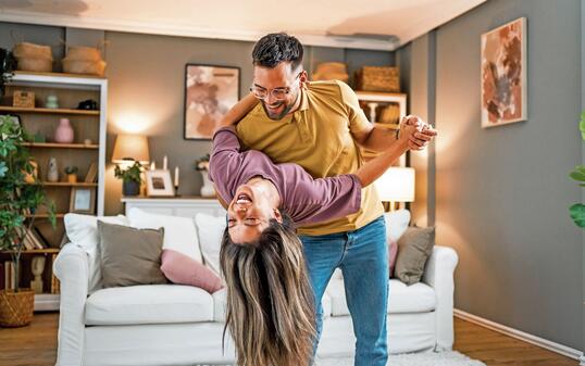 Happy couple dancing together at home