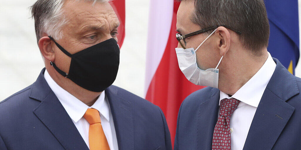 ARCHIV - Mateusz Morawiecki (r), Premierminister von Polen, trägt einen Mundschutz und begrüßt Viktor Orban, Premierminister von Ungarn, ebenfalls mit Mundschutz, zum Treffen der Premierminister der Visegrad-Staaten. Foto: Czarek Sokolowski/AP/dpa