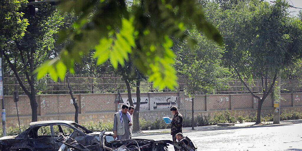 Sicherheitskräfte untersuchen den Tatort nach einem Bombenanschlag vor der Universität in Kabul - mindestens acht Menschen wurden getötet, mindestens 33 weitere erlitten Verletzungen.