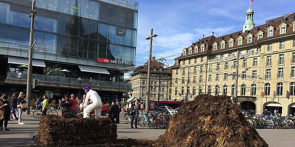 Die Aktionskünstlerin Barbara Kiener "zöpfelt" am Donnerstag auf dem Berner Bahnhofplatz Mist.