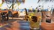 mug in the form of a skull in sunglasses on wooden table in cafe by the sea and beaches