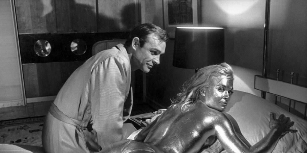 Sean Connery in der Rolle des James Bond und die vergoldete Shirley Eaton während den Dreharbeiten zu "Goldfinger" im Jahre 1964. Am Mittwoch ist dessen Regisseur Guy Hamilton mit 93 Jahren gestorben. (Archivbild)