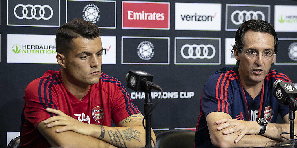 Arsenals Granit Xhaka sitzt an einer Pressekonferenz neben Trainer Unai Emery