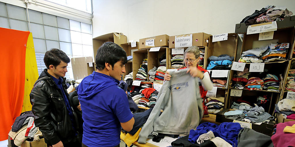 Flüchtlinge erhalten Kleider in einem Asylzentrum. Wer aber mit Vermögen in die Schweiz kommt, muss dieses abgeben, um damit die Kosten des Asylverfahrens zu decken. Etwas ähnliches will nun auch Dänemark einführen. (Symbolbild)