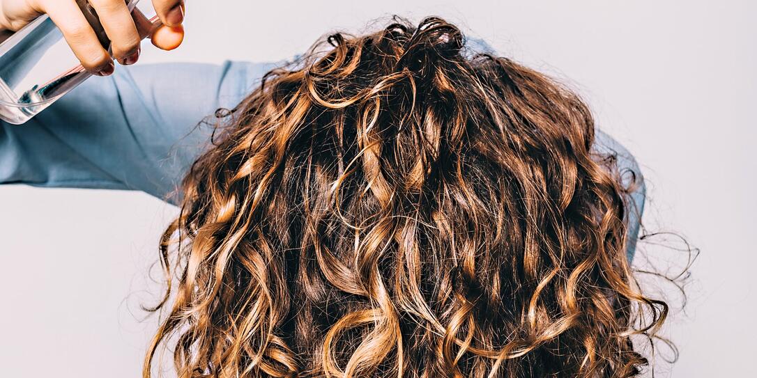 Head of young woman with long curly hair