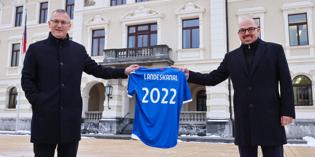 LFV Präsident Hugo Quaderer (l.) übergibt Regierungsrat und Sportminister Daniel Risch (r.) ein Leibchen der Liechtensteinischen Fussball-Nationalmannschaft, symbolisch für die Übertragung der Spiele der Nationalmannschaft über den Landeskanal.