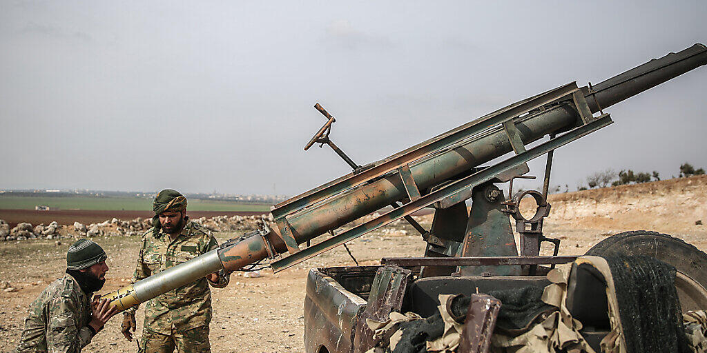 ARCHIV - Von der Türkei unterstützte Soldaten laden einen Raketenwerfer. Die vor fast zehn Jahren in Syrien ausgebrochenen Kämpfe sind 2020 weitgehend abgeklungen. Foto: Anas Alkharboutli/dpa