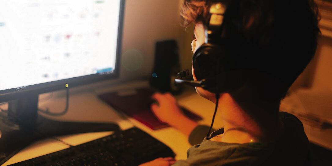 Teenage YouTuber with headphones using the computer Teenage YouTuber with headphones using the computer
