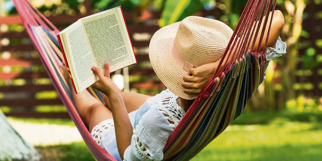 Woman reading book in hammock