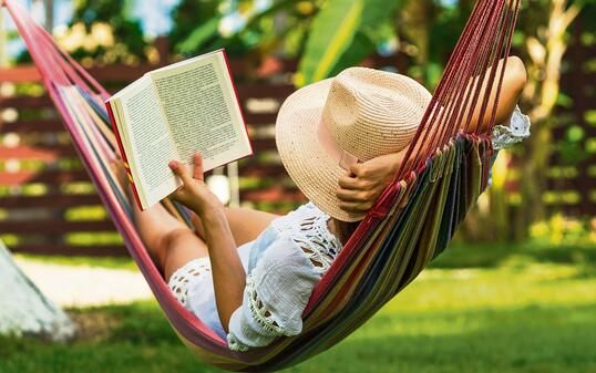 Woman reading book in hammock