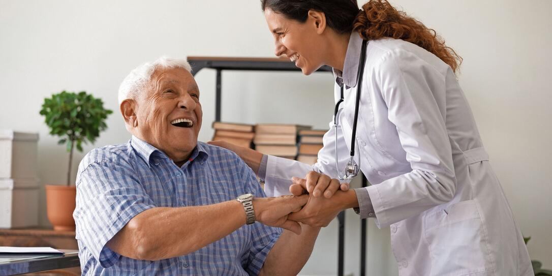Caring female doctor support and cheer elderly man