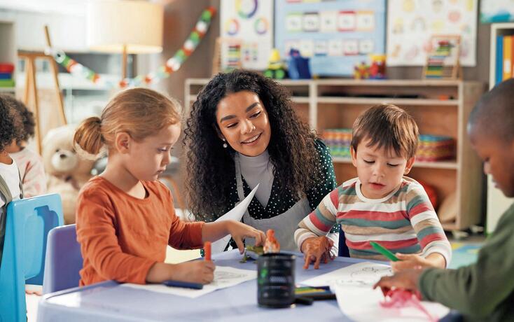 Drawing, education and teacher with children in classroom for learning, students and creative art. Growth, kindergarten and academy with woman and kids at school for helping and child development