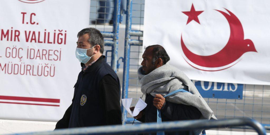 Ein türkischer Polizist (links) nimmt im Hafen von Izmir einen Mann in Empfang, der mit der Fähre von Lesbos gekommen ist.