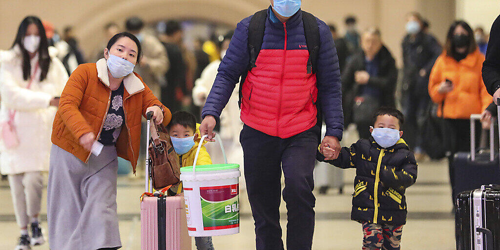 Reisende mit Gesichtsmasken im Bahnhof von Wuhan. Nach neusten Behördenangaben sind bisher 17 Menschen durch das neue Corona-Virus gestorben.