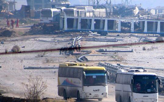 Busse bringen Rebellen und ihre Familien aus Ost-Aleppo.