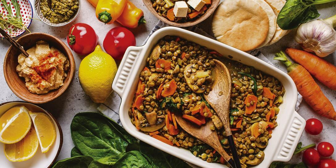 Vegan lentil curry with vegetables, top view. Healthy plant based food background.