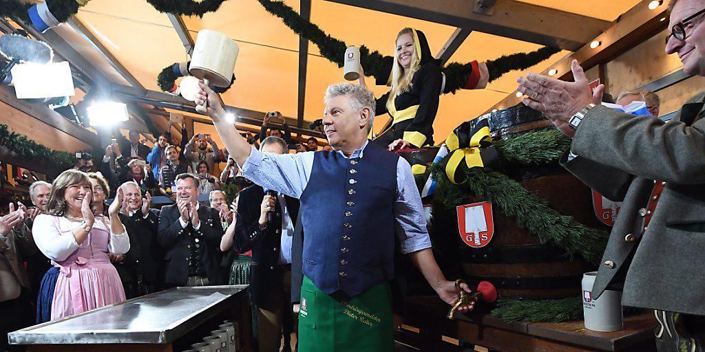 O'zapt is: Das Münchner Oktoberfest ist eröffnet. Mit nur zwei Schlägen sticht Oberbürgermeister Dieter Reiter (mit grüner Schürze) das erste Fass Bier an.