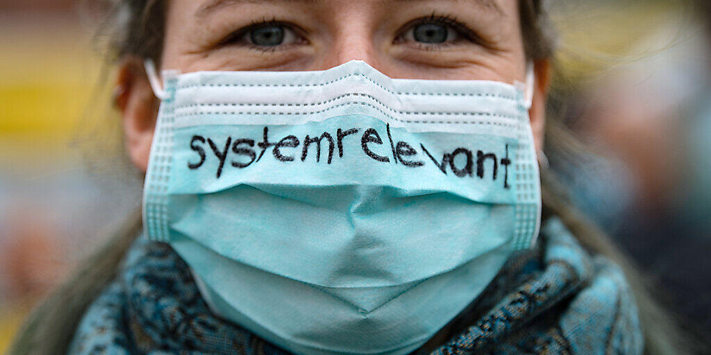 Keine Maskensünderin: Eine Krankenschwester trägt einen Mund-Nasenschutz mit der Aufschrift "systemrelevant" - dem Deutschschweizer Wort des Jahres 2020. (Archivbild)