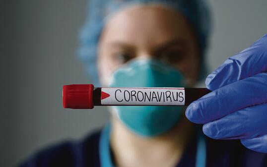 Nurse wearing respirator mask holding a positive blood test result for the new rapidly spreading Coronavirus, originating in Wuhan, China