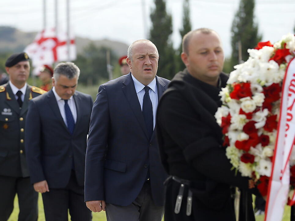 Präsident Giorgi Margwelaschwili (M) legte auf einem Friedhof bei Tiflis einen Kranz zum Gedenken an die getöteten georgischen Soldaten nieder.