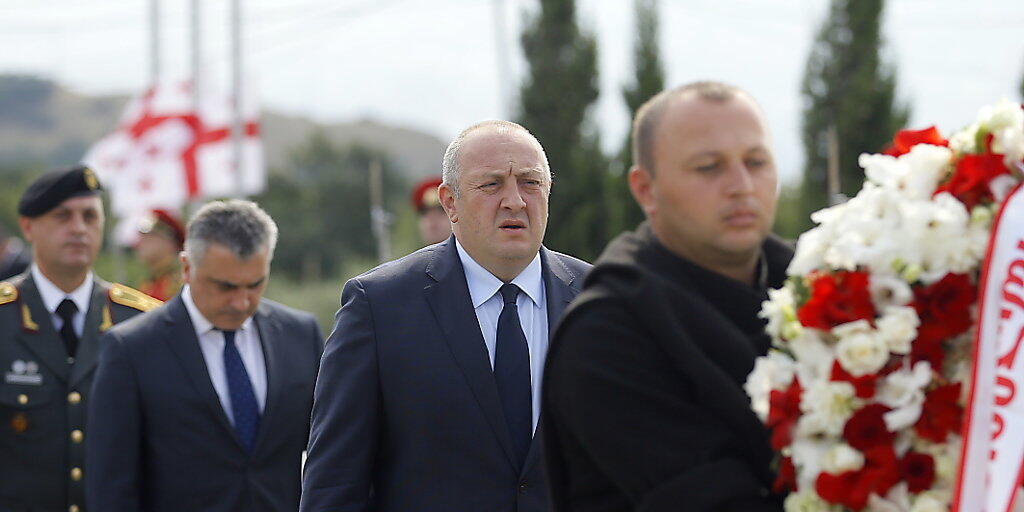 Präsident Giorgi Margwelaschwili (M) legte auf einem Friedhof bei Tiflis einen Kranz zum Gedenken an die getöteten georgischen Soldaten nieder.