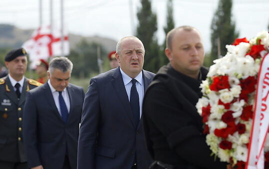 Präsident Giorgi Margwelaschwili (M) legte auf einem Friedhof bei Tiflis einen Kranz zum Gedenken an die getöteten georgischen Soldaten nieder.