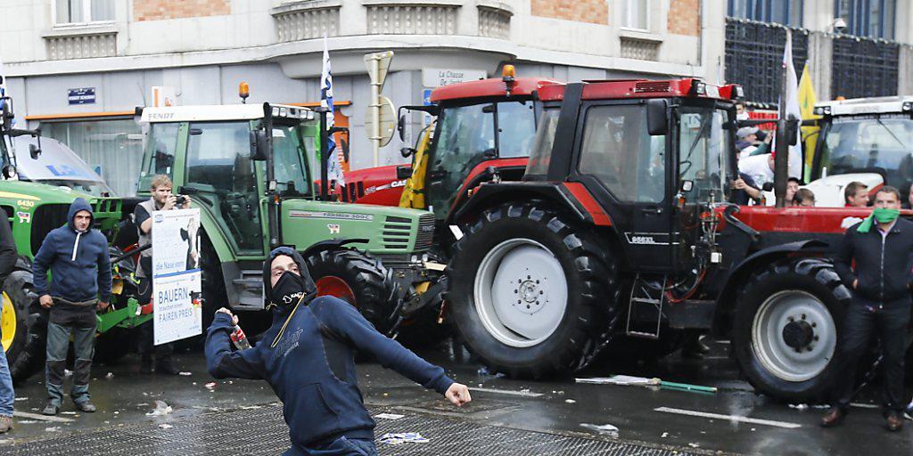 Bauern protestieren in Brüssel gegen den Preiszerfall: Ein Mann schleudert eine Flasche in Richtung der Polizisten. Bauern protestieren in Brüssel gegen den Preiszerfall: Ein Mann schleudert eine Flasche in Richtung der Polizisten.