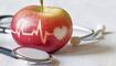 Heartbeat line on red apple and stethoscope, healthy heart diet concept