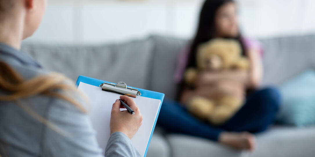 Teenage depression. Psychologist working with teen girl at office, talking to her patient, taking notes, selective focus Teenage depression. Psychologist working with teen girl at office, talking to her patient, taking notes, selective focus