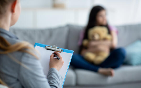 Teenage depression. Psychologist working with teen girl at office, talking to her patient, taking notes, selective focus